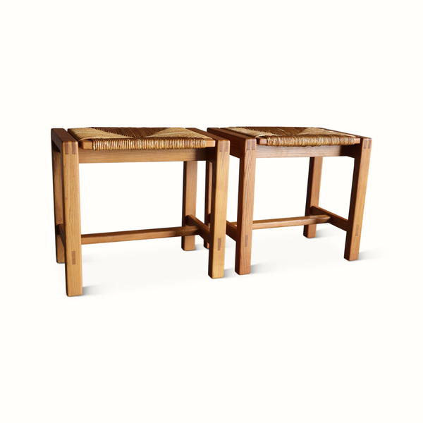 Pair of wooden stools with woven rush seats, square legs, and cross bracing