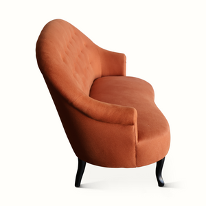 Orange-brown velvet sofa with padded rolled arms, deep seat, and dark tapered legs