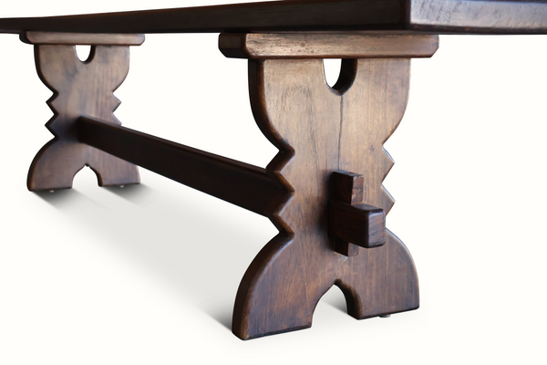 Carved wooden bench legs with zigzag cutouts under the tabletop