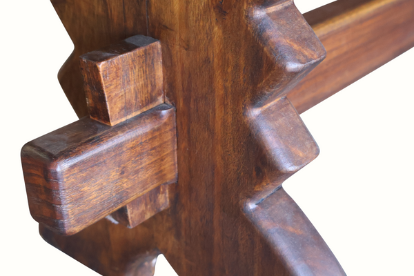 Close-up of carved wooden pedestal detail on dark brown bench