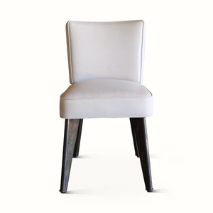 Modern leather accent chair with rounded back, light upholstery, and dark legs