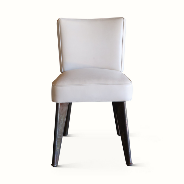 Modern leather accent chair with rounded back, light upholstery, and dark legs