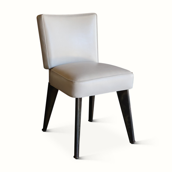 Leather accent chair with light seat, padded backrest, and dark angled legs