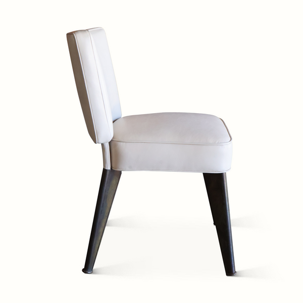 Light leather accent chair with tall back, cushioned seat, and dark wooden legs
