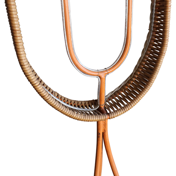 Floor lamp base close-up with woven rattan ring and dark metal and wooden tubes