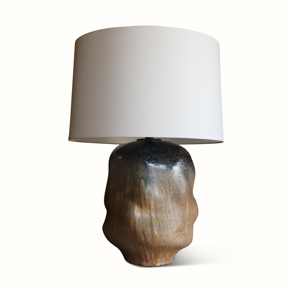 Brown glazed ceramic table lamp with off-white drum shade, side view