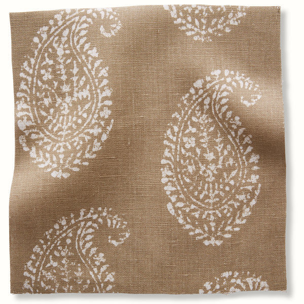 Paisley textile fabric swatch with white ornamental motifs on stone background