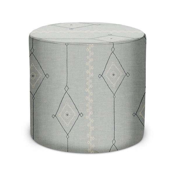 Round upholstered indoor pouf, light gray fabric with blue geometric pattern, padded top