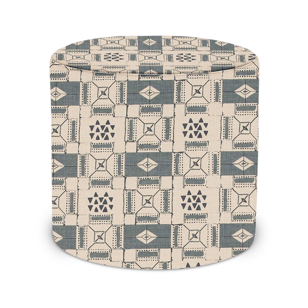 Indoor pouf with blue and cream geometric fabric cover, rounded top.