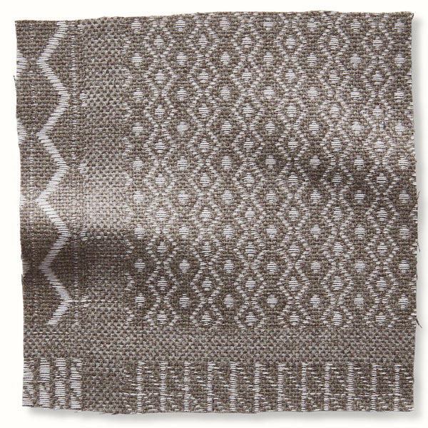 Square outdoor pillow cover with woven geometric pattern, zigzag border, and short fringe in natural and white