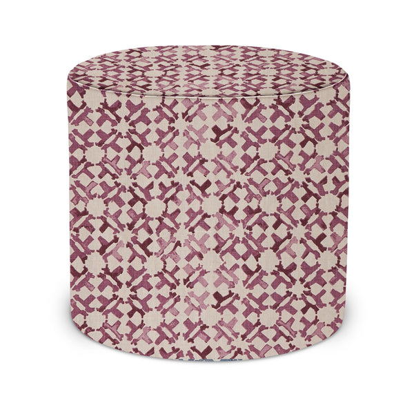 Indoor pouf with pink and cream geometric lattice fabric top and round upholstered sides