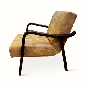 Patchwork leather accent chair with arched dark wood arms, tan quilted seat and back