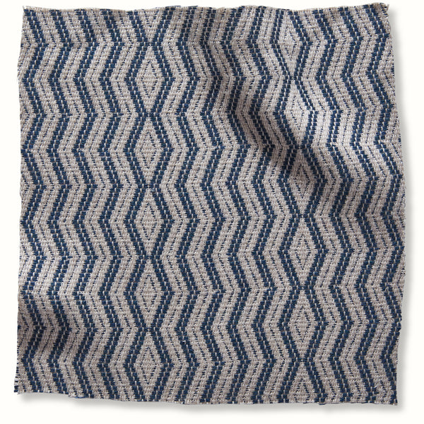 Outdoor pillow cover with indigo woven diamond and zigzag pattern on natural fabric
