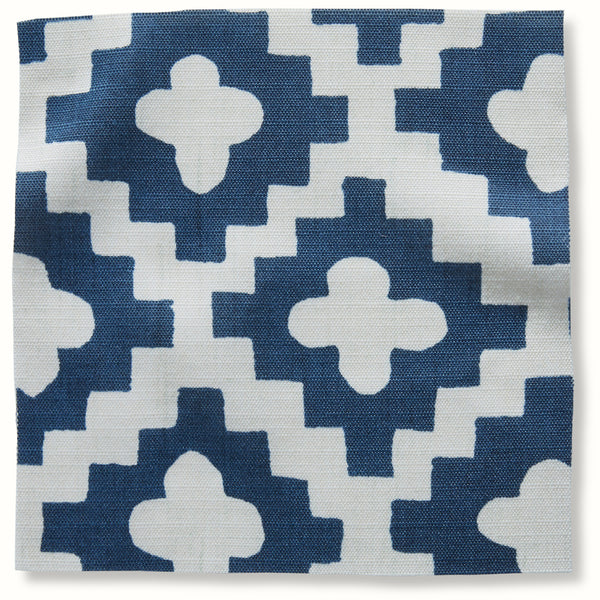 Indigo outdoor pillow cover with repeating white geometric flower pattern