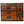 Wooden tansu chest with four drawers and decorative metal hardware, orange-brown wood.