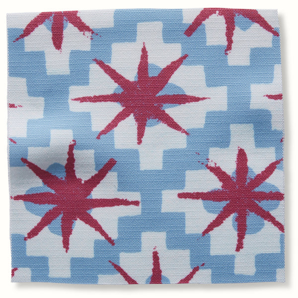 Outdoor pillow cover with blue geometric pattern and red starburst motifs