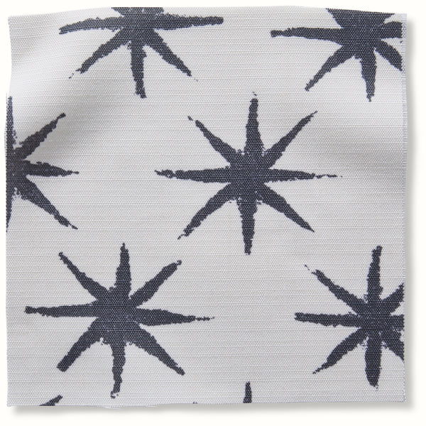Outdoor pillow cover with charcoal starburst pattern on light background
