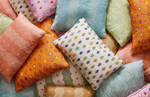 A pile of colorful pillows in different patterns.