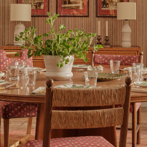 Upholstered armchair with patterned red seat, visible wood arms and legs