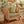 Green and gold patterned outdoor pillow, square shape