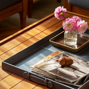 Rectangular wooden coffee table with slatted top and brown leather storage tray