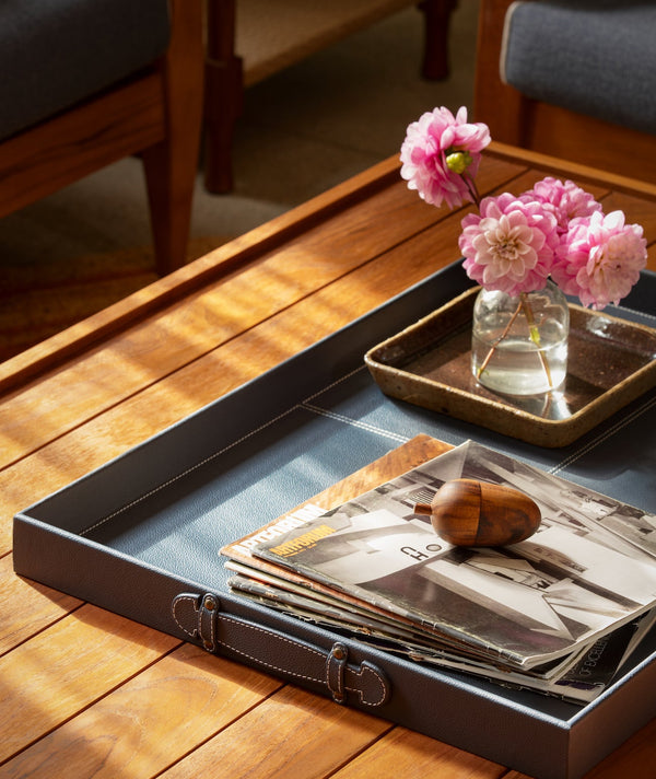 Rectangular wooden coffee table with slatted top and brown leather storage tray