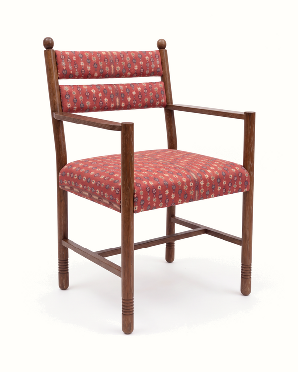 Upholstered armchair with red patterned fabric cushion, light walnut wooden arms and legs