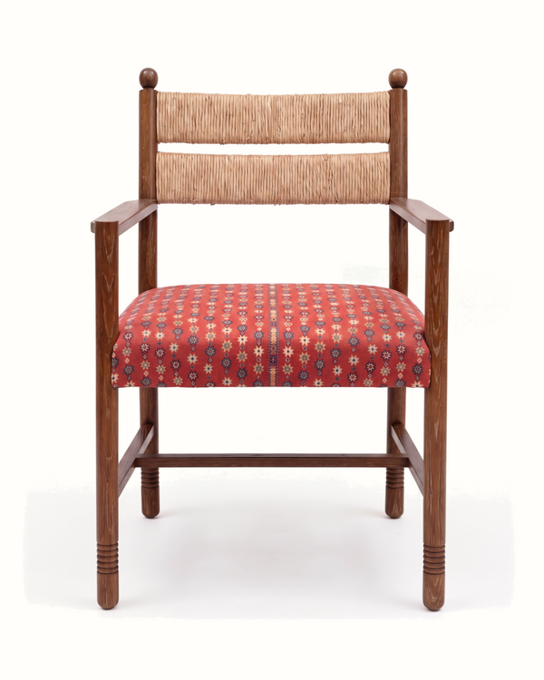 Wood armchair with rush back and red patterned upholstered seat cushion