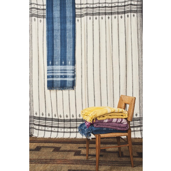 Folded striped throw blankets on a wooden chair