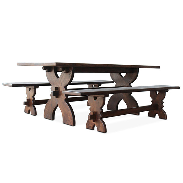 Vintage walnut bench with dark plank top, curved trestle supports, and turned legs
