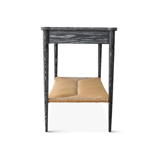 Black console table with woven paper rush seat shelf and carved side posts.