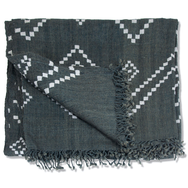 Charcoal bedcover folded with white zigzag pattern and fringed edge detail
