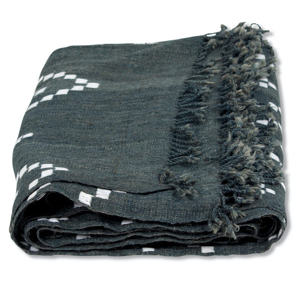 Rolled charcoal bedcover with white zigzag accents and dense fringed border