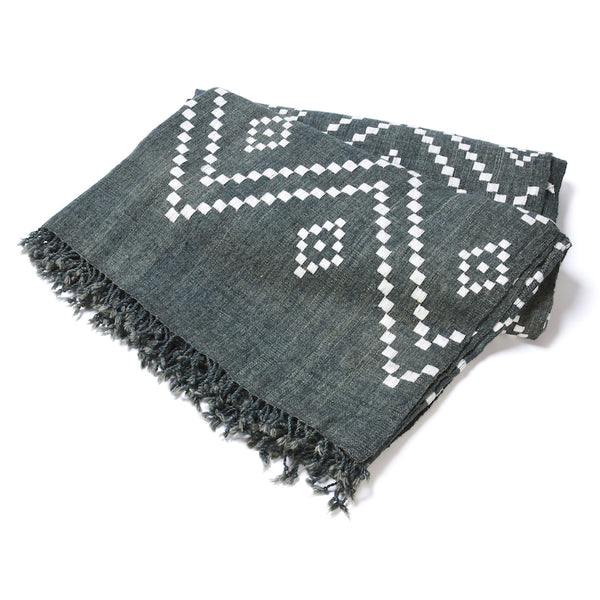 Charcoal bedcover with white zigzag and diamond motifs, fringed border, folded view