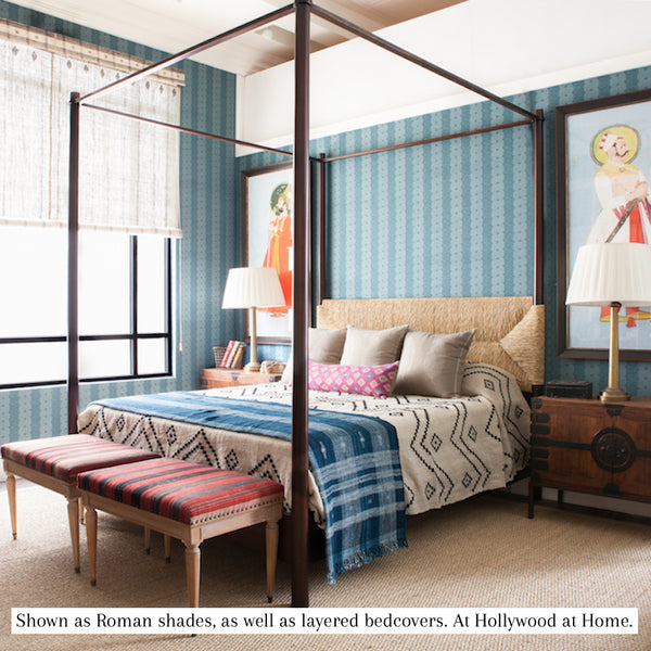 Indigo and ivory striped textile shown across bedding with geometric diamond motifs