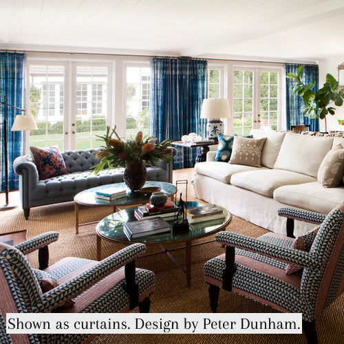 Indigo and ivory striped curtain panels with fringe trim in a living room setting