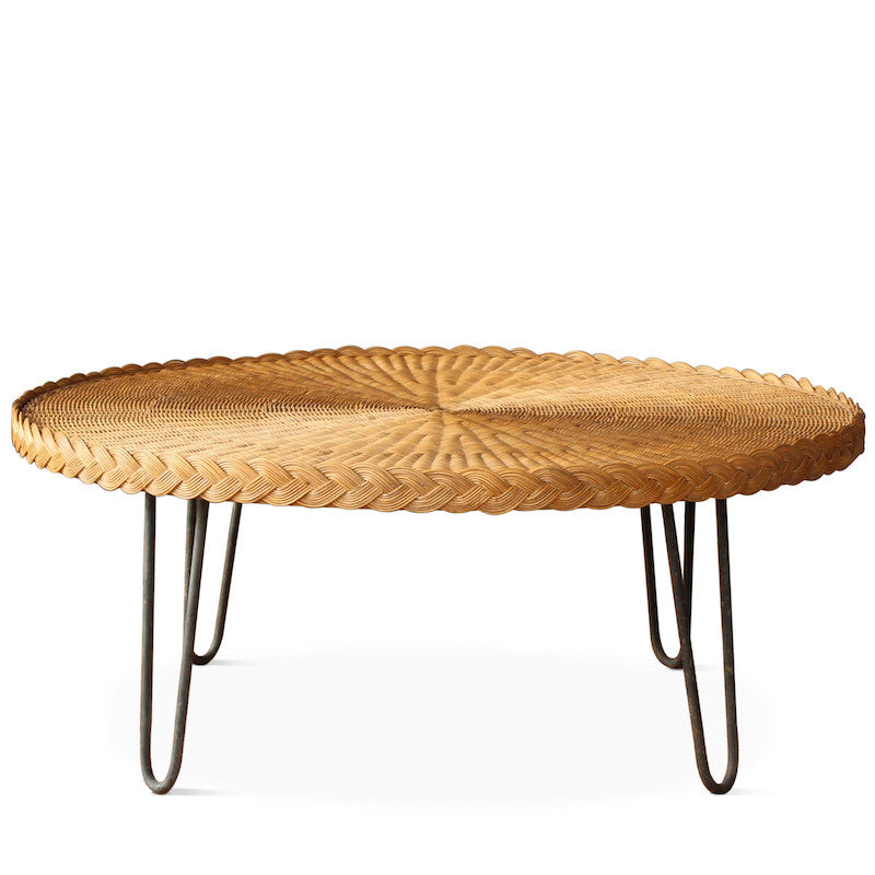 The San Remo Coffee Table features a circular wicker top with mid-century styled hairpin iron legs in a rustic patina. The table is completely handmade in Los Angeles and designed by Hollywood at Home founder Peter Dunham.